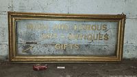 Full view of the vintage glass sign with gold frame showing complete text and condition.