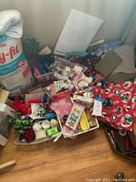 Photo shows a large bag of Poly-Fil Premium Polyester Fiber Fill with assorted craft supplies including artificial berries, feathers, beads, and fabric pieces in bins on the floor.