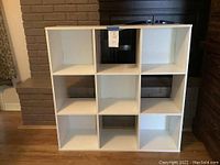Front view of the white cubby shelf showing nine square compartments.