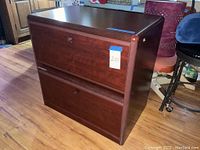 Front view of the two drawer dark wood lateral file cabinet with label 210 and measurement tape on top