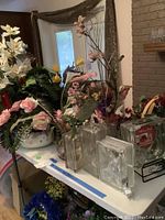 Table with silk flower arrangements and clear glass block vases