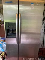 Front view showing stainless steel doors, integrated ice and water dispenser on left door.