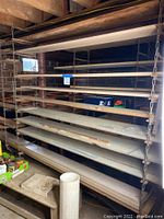 Wide view of first chain hung shelving unit with wooden plank shelves suspended by heavy metal chains