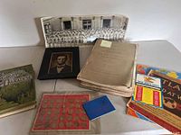 Overview of all lot contents including books, coin board, prints and ephemera