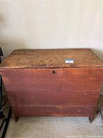 Front view of the antique wooden chest showing lock keyhole and overall shape