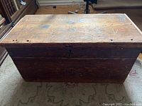 Top and front view of the large antique wooden chest showing weathered surface and metal latch