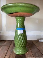 Front view of the pedestal and underside of the bowl showing thick ceramic construction and glossy green finish.