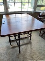 Photo of wooden drop leaf table with both leaves open showing table top and leg design