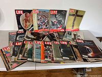 Overview of the collection displayed on a table showing 19 LIFE magazines front covers from the 1960s.