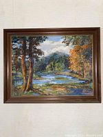 Landscape painting with river, trees in autumn colors in brown wooden frame