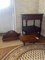 Full view of all three wooden furniture items on floor: table with drawers, stool, and tool carryall