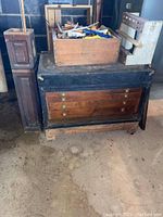 Overall shot of wooden chest with removable tray and assorted tools on and around it