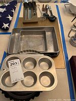 Metal muffin tins and baking pans stacked showing condition and size