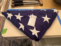 Image showing the large American flag folded into a triangular shape, with white stars on blue field clearly visible.