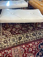 Front and top view of a white leatherette mid century bench, showing tufted diamond pattern and buttons.