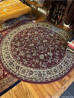 Round oriental rug measuring 62 inches diameter on hardwood floor with surrounding furniture.