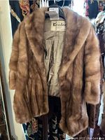 Brown vintage fur stole displayed hanging, showing full front side and plush fur texture.