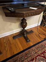 Full view of vintage wooden table showing rectangular top, carved edges, and pedestal base with four legs