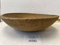 Photo showing side angle of the large wooden butter bowl displaying its shape and surface texture.