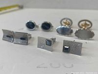 Full view of 5 vintage men's cuff links arranged in two rows showing different styles and details.