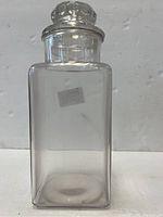 Full view of the clear glass square apothecary jar showing its size and shape.