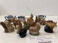 Group photo displaying all Wade ceramic miniature figurines and Red Rose teapot models in a collection, featuring various animal shapes and small house figurines on a flat surface.