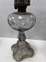 Photo showing the full lamp with bulbous clear glass reservoir and decorative glass base