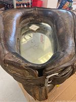 Close-up of the horse collar mirror showing the leather surface and embedded rectangular mirror with visible wear.