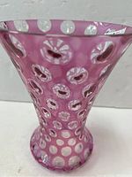 Full view of large cranberry glass vase showing thumbprint pattern and flared shape.