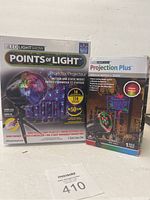 Two boxed LED light show projectors side by side showing product branding and features.
