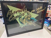 Front view of black framed illuminated sign with Spider-Man crawling and 'Marvel Comics on sale here!' graphic
