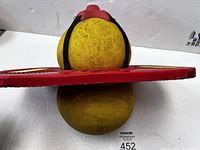 Side view of the vintage Zingo Pogo jumper showing foot grips and straps securing the yellow inflatable ball on red molded plastic base.