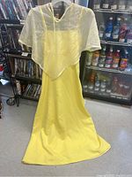 Full view of the yellow vintage gown with sheer white floral cape attached, showing overall garment and cape details