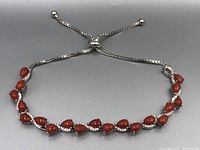 Front view of the adjustable coral and sterling silver bracelet showing the length and chain detail.