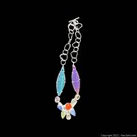 Full view of the necklace showing the iridescent colorful stones arranged in floral and leaf shapes with attached linked silver-tone chain