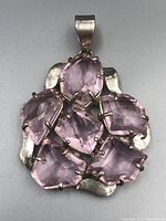 Front view of vintage sterling silver pendant with pink gemstones, showing faceted cut and metal setting.