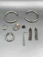 Photo showing all sterling silver jewelry pieces in the lot, including various earrings and ring arranged on a white background.