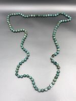 Full view of the turquoise beaded necklace laid out showing length and bead size.