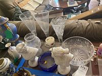 Wide shot showing multiple items including crystal bowl, ashtray, busts, candle holder, tea cup and vase.