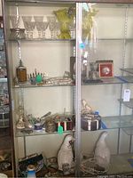 Full view of shelving showing crystal stemware, art glass vases, amber jar and duck lamps