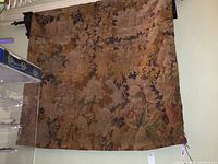Full view of tapestry hung on rod against wall