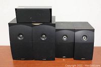 Two sets of bookshelf speakers and one center channel speaker, showing condition and brands