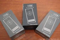 Three black boxes each labeled Enhence Instant Translator on wooden surface.