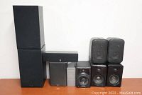 Various mismatched speakers stacked and arranged, showing three pairs and multiple singles in black and grey colors.