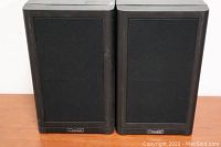 Pair of Mission 760i bookshelf speakers front view with black fabric grills and Mission logos