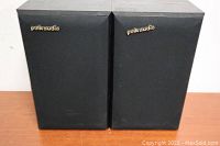 Pair of Polk Audio bookshelf speakers with black fabric front covers, placed side by side.