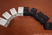 All boxed Topgreener occupancy sensor pin wall switches and Electeck wall outlets arranged in arc on wood surface.