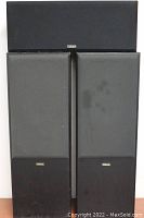 Front view of the Yamaha NS-894 MKII tower speakers with black grills and wood lower panel, showing some wear marks.