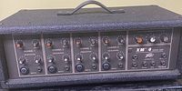 Front panel view showing all four channel gain and equalization controls and inputs along with master section controls and input/output jacks.