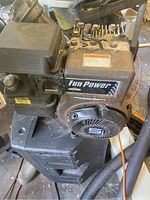View of the Briggs & Stratton engine showing the air filter cover and pull start housing with the 'Fun Power' label.